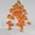 Detail shot of hanging orange artificial lantern fruit flower vine for wedding decor. - Orange