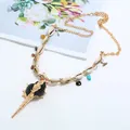 Nahaufnahme Detailansicht der boho Muschelkette mit schwarzem Schneckenanhänger und Kette. - Schwarz