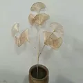 Detail view of golden metal ginkgo leaf branch simulation plant decor in ceramic vase. - Wealthy Fan