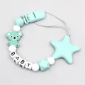 Detalle macro de un sujetachupetes de silicona verde menta con bonitas cuentas de koala y estrella - Verde claro
