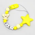 Detail showing silicone koala and star charms on a yellow baby pacifier clip - Yellow