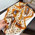 Luxury silk scarf featuring elegant equestrian and horse harness print in vibrant orange and white. - 19108-Main Image