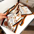 Luxury silk scarf featuring elegant equestrian chain print, premium fashion accessory for women. - Orange