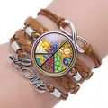 Close-up detail showing peace sign, infinity, and Love charms on a braided leather bracelet - Brown