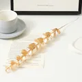 Close-up detail of golden artificial eucalyptus leaf branch, perfect for floral decoration. - Single Eucalyptus Stem / Gold