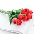 Gros plan détaillé d'un bouquet de tulipes artificielles rouges pour décoration intérieure. - Rouge