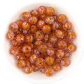 Close-up detail of Japanese millefiori glass beads with glitter and facets for DIY crafts. - Orange