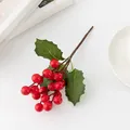 Détail de branche de baies rouges artificielles, parfait pour la décoration florale de Noël. - Feuilles épineuses et baies rouges