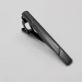 Close-up detail van de zwarte metalen dasclip, met strakke lijnen en een minimalistisch ontwerp. - Zwart