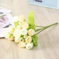 Close-up detail of artificial mini rose bouquet, cream yellow flower buds with green leaves. - Chunxing / Light Yellow