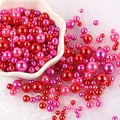 Vista di dettaglio di perle rosse e rosa di varie dimensioni su sfondo soffice bianco - Perle Tonde Perforate / Circa 8000 Pezzi/Pack / Combinazione Rosa Rosso Fucsia (NO.34)