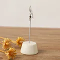 Minimalistischer Fotohalter mit cremefarbener Basis auf Holztisch. - Beige