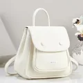 Close-up detail of white pebbled leather backpack showing flap and textured finish - White