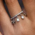 Detailed close-up of a silver ring with sparkling pear-shaped tassel drops on a finger. - Size 6 / Tassel Crescent Moon Style (KYRA02111) / Silver