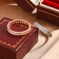 Close-up of rose gold and silver square-cut CZ eternity band rings on a jewelry box - Size 6 / Rose Gold