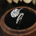Primer plano de un anillo con diamante de laboratorio y un diseño de banda ondulada - Talla Única Ajustable / Plateado (KYRA02108 Color Oro Blanco)
