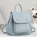 Close-up of a light blue pebble leather backpack featuring elegant fashion bags branding - Blue