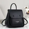 Detailed macro view of a minimalist black pebbled leather backpack with fashion logo - Black
