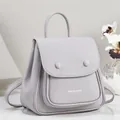 Detailed view of grey pebbled leather backpack with elegant top handle and flap pocket - Gray
