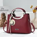 Elegant wine red lychee grain handbag with unique metal ring handles and hat charm - 23x11x18cm / Jujube Red
