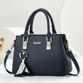 Elegante marineblauwe handtas met goudkleurig logo en een stijlvolle sjaalhanger. - 28x12x20cm / Saffierblauw