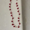 Detailweergave van handgemaakte ketting met rode kristallen kralen in bloempatronen - Rood