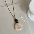 Dettaglio dell'elegante ciondolo in resina effetto marmo della collana lunga - Geometrico (Stile 3)