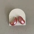 Macro view of pink metallic bean earrings with irregular hammered texture on arch card - Hammered Bean Style / Metallic Pink