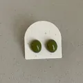 Macro detail of minimalist olive green oval stud earrings with a glossy bean-shaped finish - Geometric Bean Style / Olive Green
