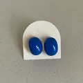 Close-up of blue glossy bean-shaped enamel stud earrings on a textured white card - Geometric Oval Bean Style / Blue