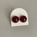 Close-up of glossy burgundy round bean stud earrings on a white textured display card holder - Round Bean Shape Style (Style 37) / Burgundy