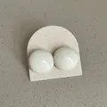 Close-up of minimalist cream-colored round bean stud earrings with glossy finish - Geometric Round Bean Style (Style 20) / Cream