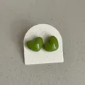 Macro view of bright green heart-shaped stud earrings with glossy enamel finish. - Heart Shape Style / Grass Green
