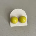 Detailed close-up view of vibrant yellow enamel bean-shaped stud earrings on a card - Round Bean Style / Bright yellow