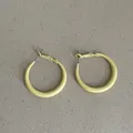 Macro detail showing the bright yellow oil-dripping matte finish of these hoop earrings - Geometric Ring Style / Lemon Yellow