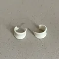 Detail view of off-white geometric bean-shaped hoop earrings on textured background - Geometric Bean C-Shape Style (Style 31) / Off White