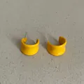Close-up macro view of vibrant bright yellow enamel geometric C-shaped stud earrings - Geometric C-Shape Style (Style 32) / Bright yellow
