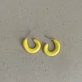 Close-up of bright yellow bean-shaped geometric earrings on a textured background. - Geometric Bean Shape Style (Style 36) / Bright yellow