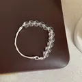 Détail d'un bracelet minimaliste en quartz clair avec élément en métal argenté - Bracelet Modèle 16 (Cristal et Barre Métallique Irrégulière)