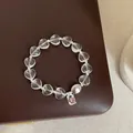 Vue détaillée d'un bracelet en cristal de roche clair avec perles en cœur et argent S925 - Bracelet Modèle 11 (Perle Cœur Étiquette S925)