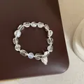 Detailed macro view of clear irregular white crystal beads and a silver pinecone charm - Model 2 Bracelet (Pinecone Pendant)