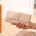 Close-up detail of a pink pebble leather long wallet with gold buckle hardware - Pink