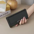 Minimalist black leather long wallet for women featuring an elegant silver metal bar detail - Black