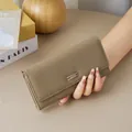 Minimalist women's long taupe pebbled leather wallet featuring a stylish metal bar buckle closure - Khaki