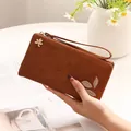 Elegant brown long PU leather wallet for women featuring leaf print and wrist strap - Brown