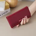 Elegant burgundy long leather wallet with minimalist design and textured finish. - Red
