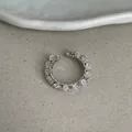 Detalle en primer plano de un elegante ear cuff plateato con cristales rosa y claros - Anillo de Circonita Rosa