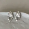 Detailopname van geometrische holle druppel zilveren metalen oorknopjes in minimalistische stijl - Zilver