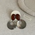 Nahaufnahme von Vintage-Ohrringen aus Muschel und Holz auf neutralem Stoffhintergrund. - Stil 3 Ohrringe