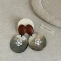 Detailansicht der Retro-Ohrringe aus Muschel und Holz mit zartem Blumenmotiv. - Stil 4 Ohrringe